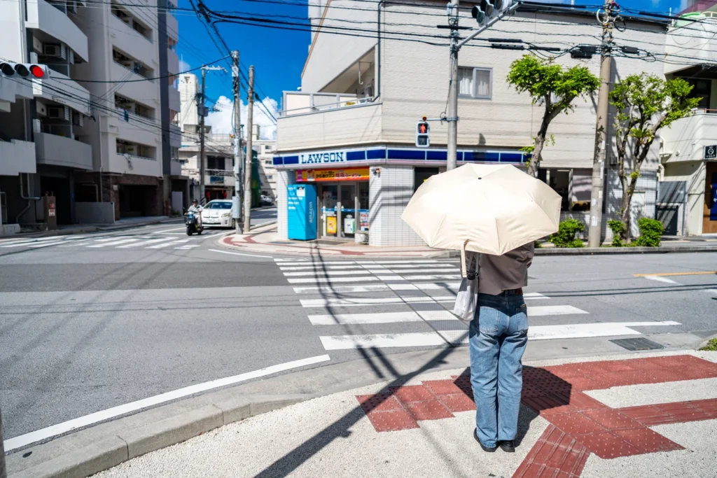 2025年8月17日沖繩天氣,這是一位在美榮橋撐陽傘的女性。在這樣的陽光下,建議使用陽傘。