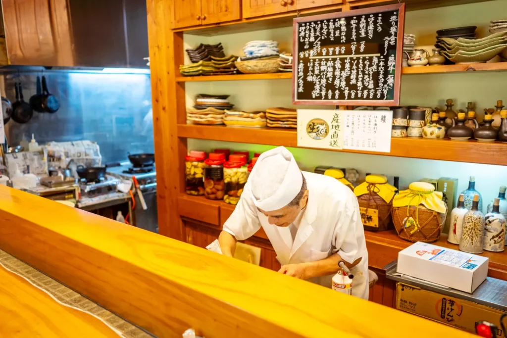 沖縄の美味しいお店、季節料理 湯川で盛り合わせ寿司を準備中の寿司職人