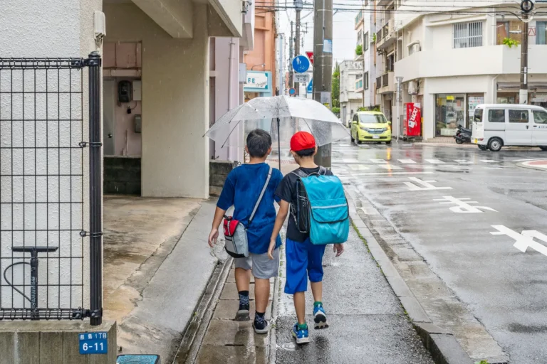 2nd September 2025, Okinawa Weather: Children with Randoseru and Umbrellas on a Rainy Day