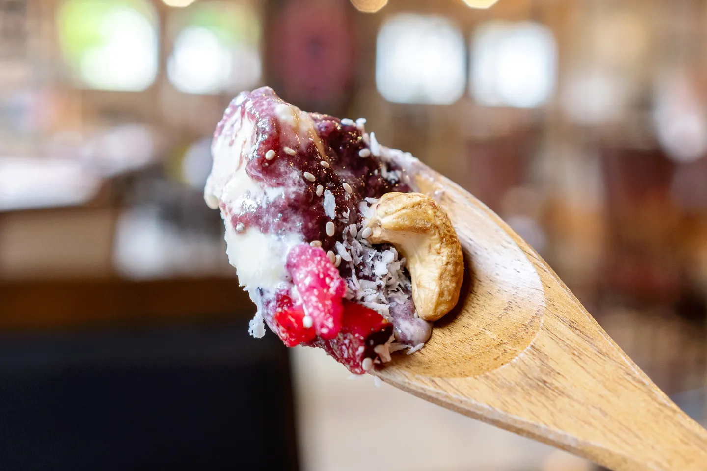 Ein Löffel Acai-Bowl, Nüsse und Obst sowie Eis bilden die Hauptbestandteile.