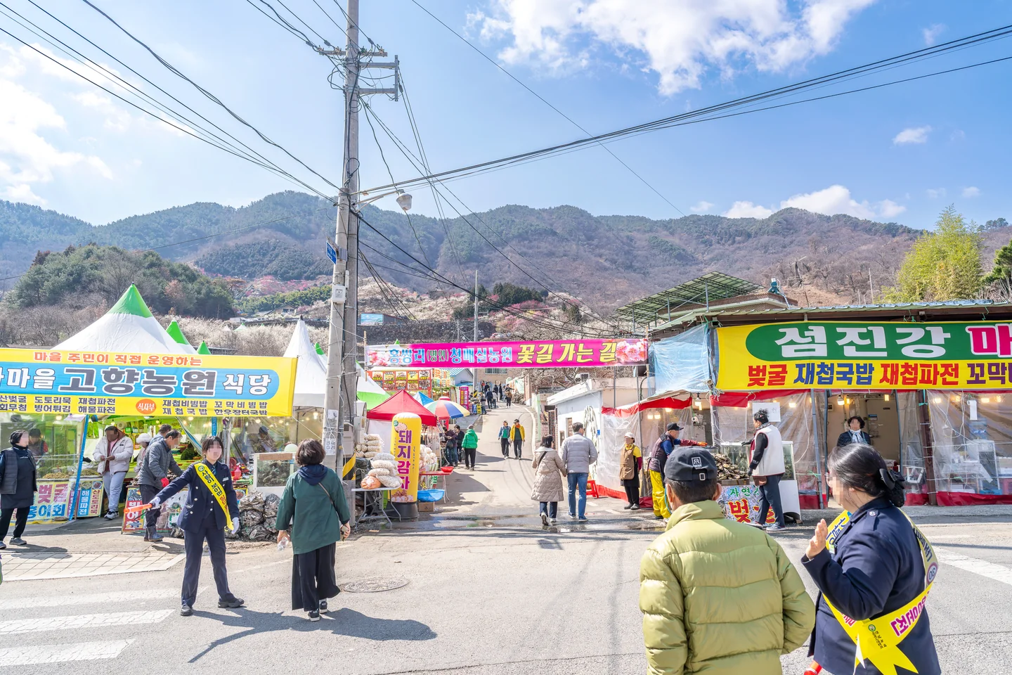 상점과 사람들로 붙은 마을 입구 길
