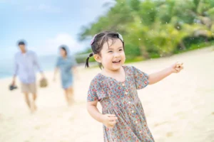 해변에서 웃으며 손짓하는 아이