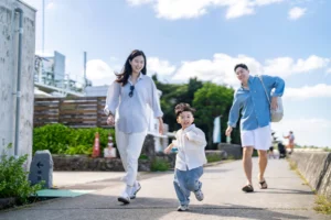 산책로를 신나게 달려오는 아이와 뒤따라 뛰는 엄마와 아빠