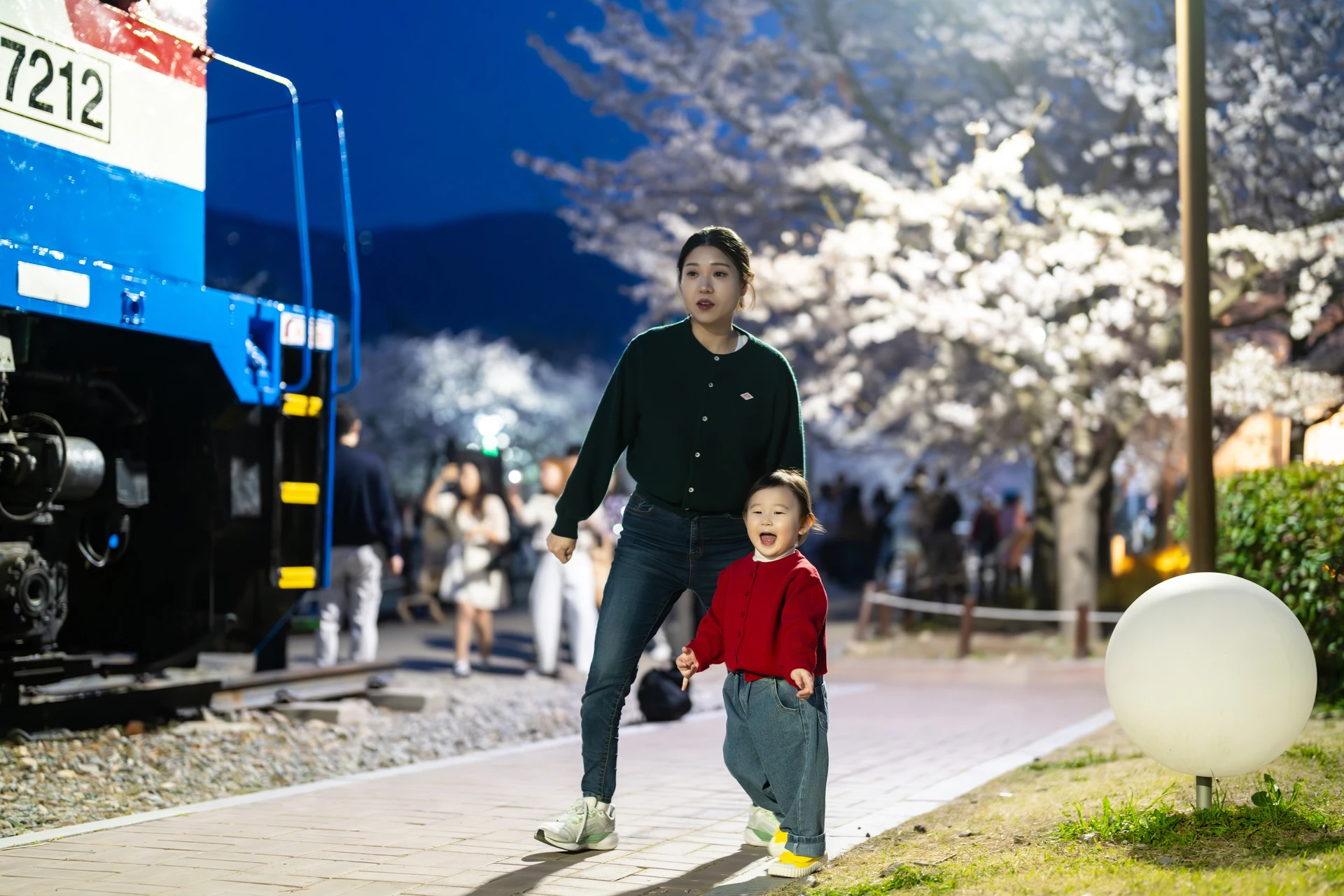 기차 옆 길을 뛰어가는 아기와 따라가는 엄마