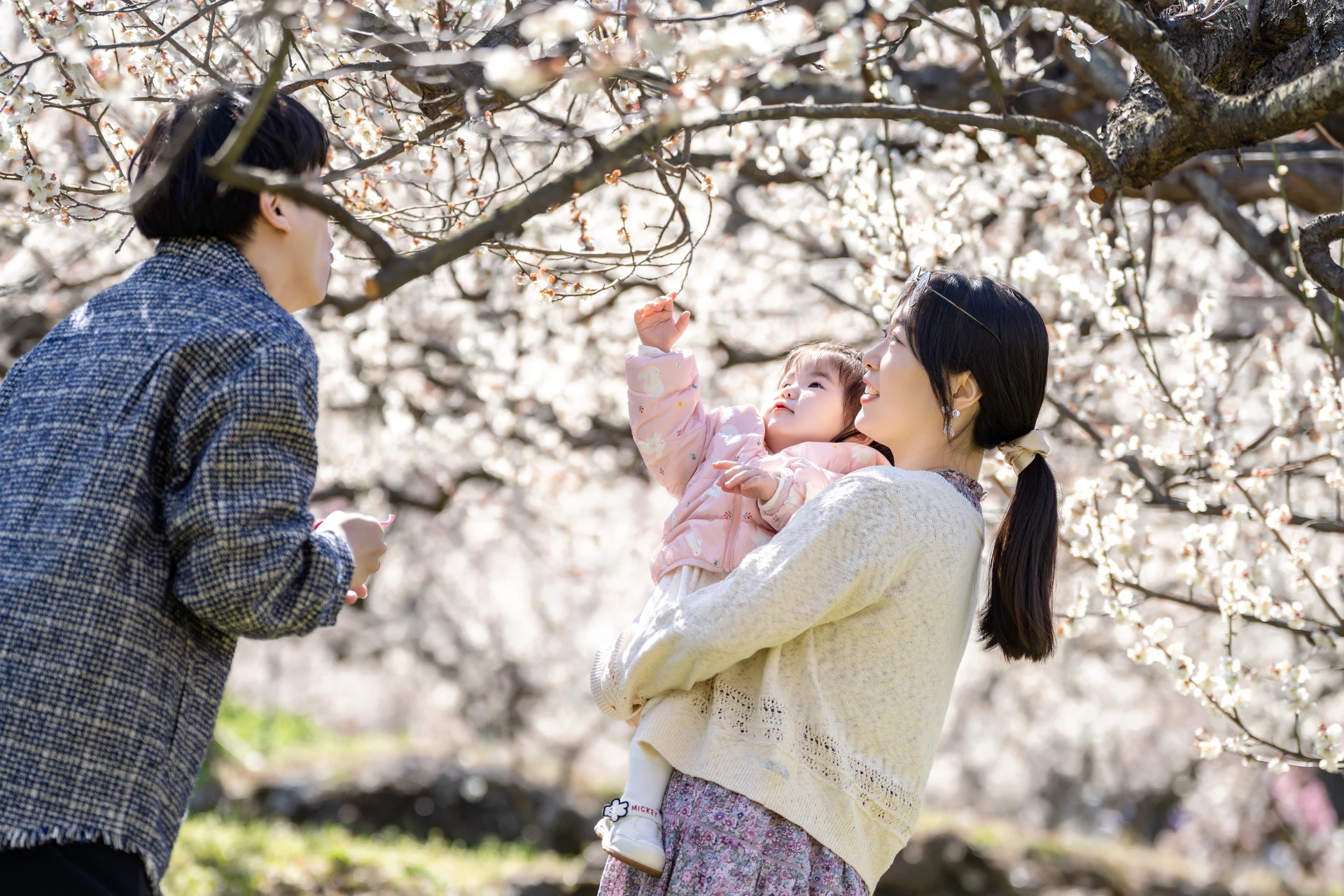 아기를 바라보며 손을 뻗는 엄마와 아빠