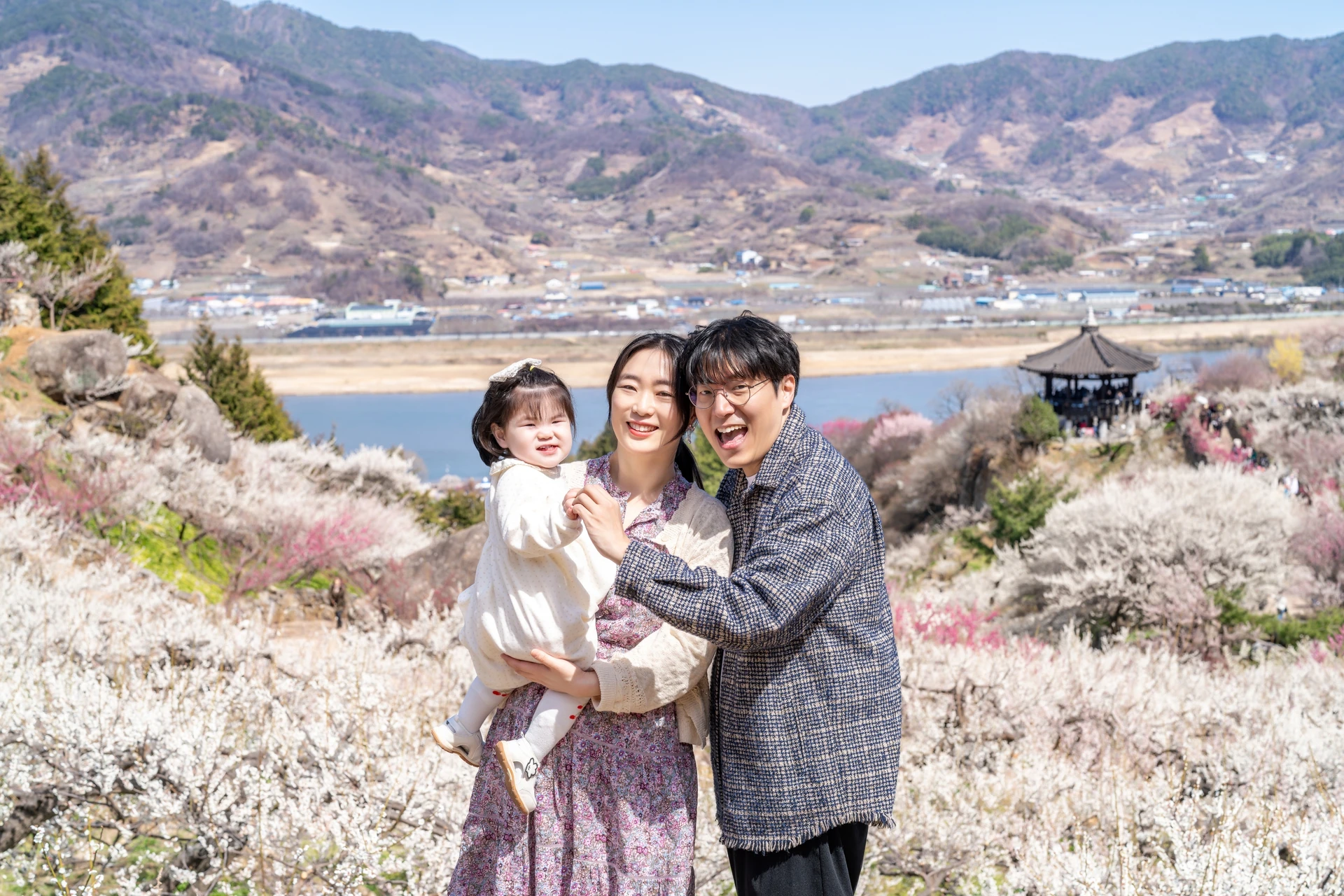 섬진강과 매화밭을 배경으로 선 가족
