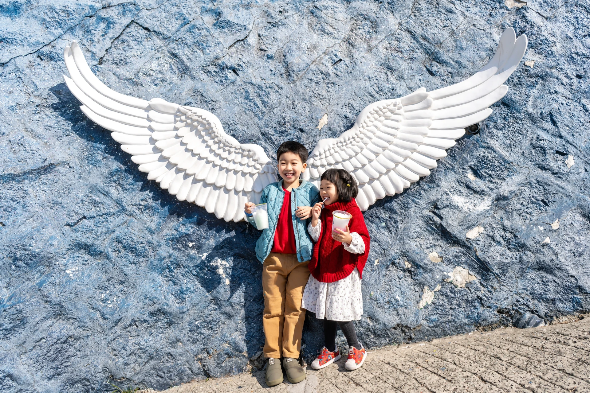 날개 벽화 앞에 선 남매