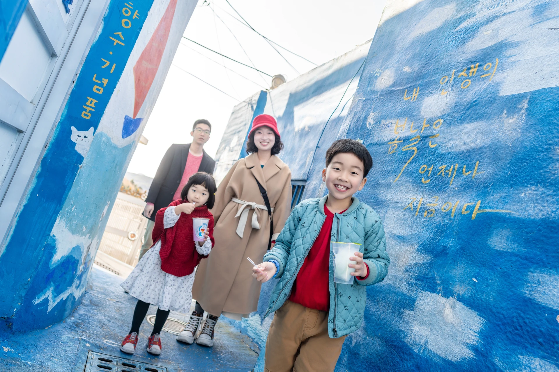 푸른 벽화 골목을 걷는 가족