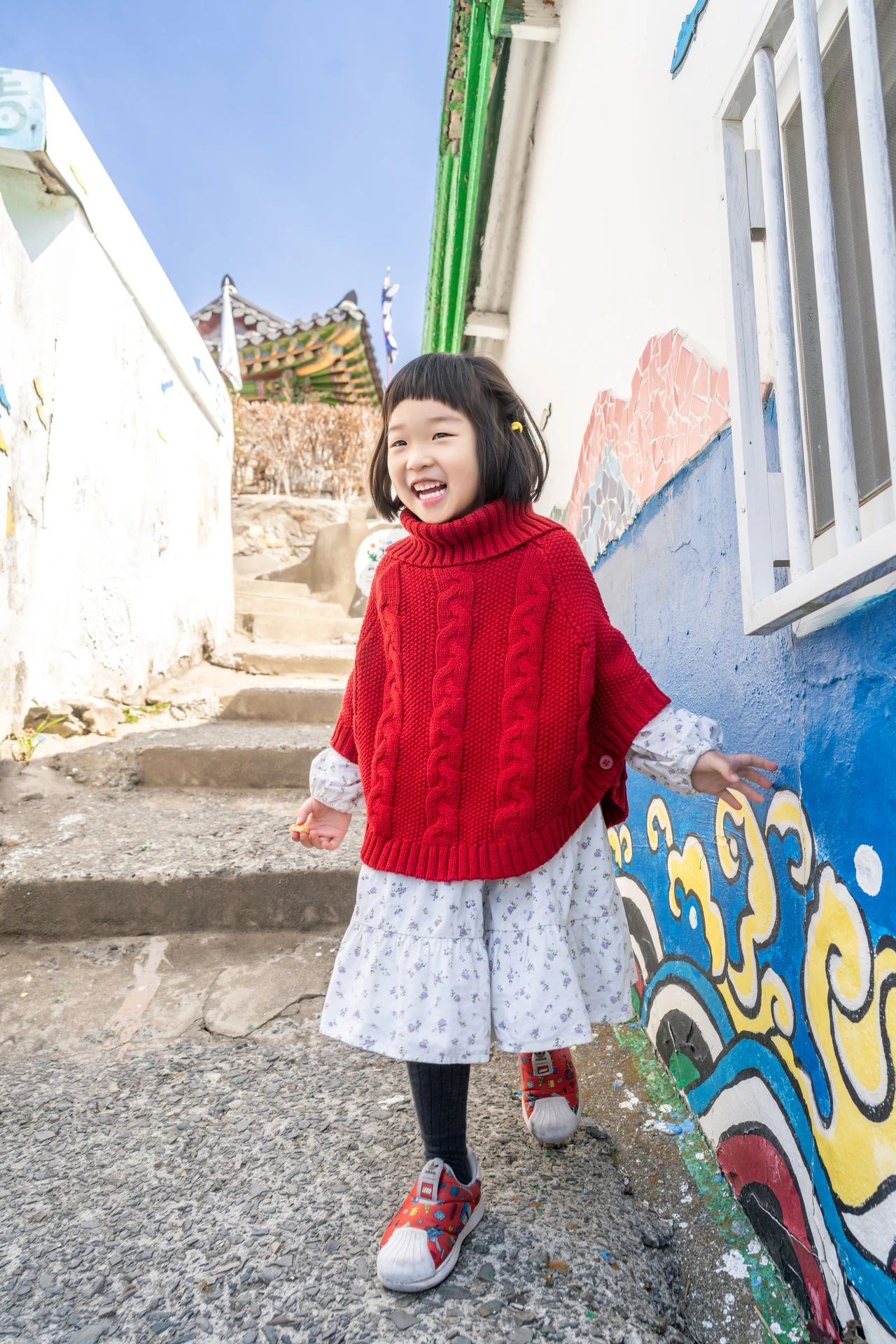벽화 옆 계단에 선 여자아이