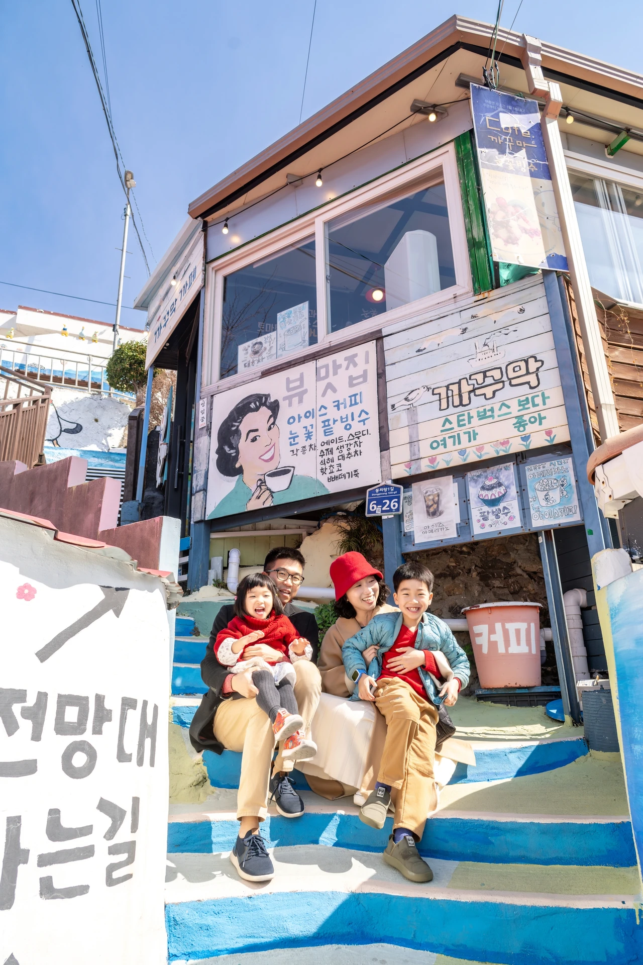 파란 계단에 앉은 가족