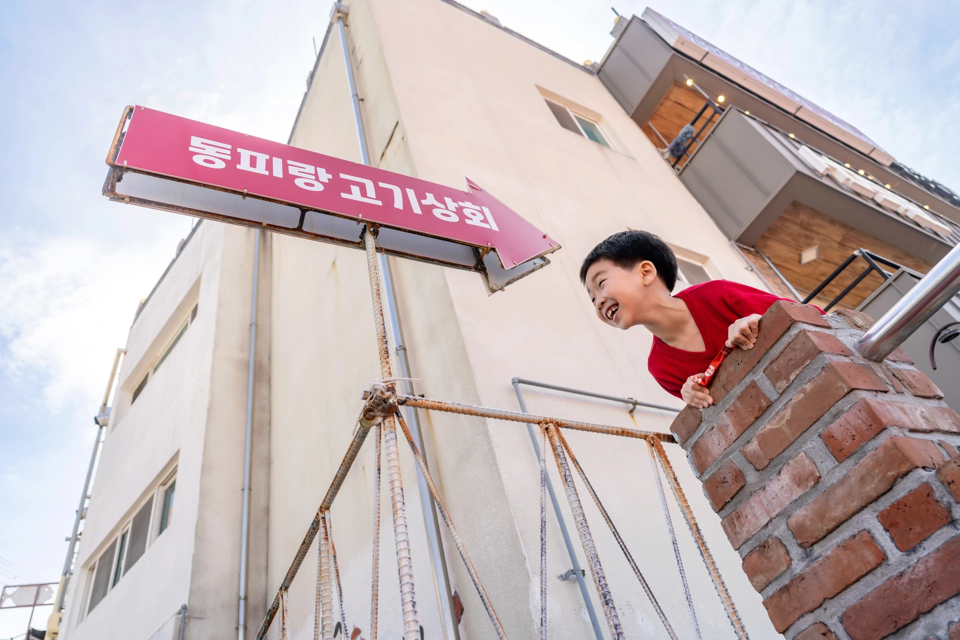 동피랑 고기상회 간판 옆의 남자아이