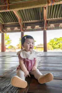 세병관 마루에 앉아 입을 오므린 아기